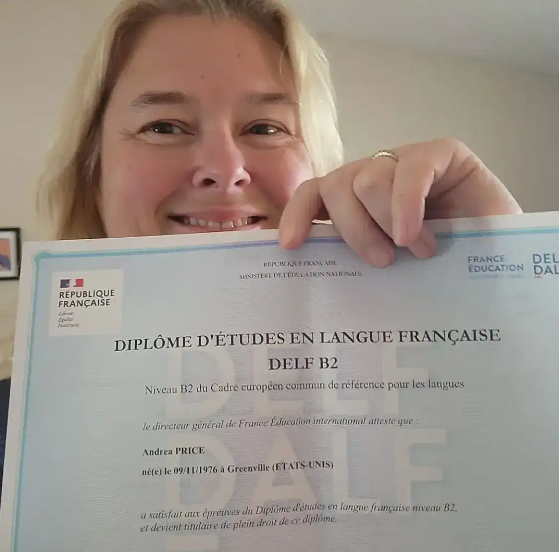 Andrea proudly shows her DELF B2 French diploma.